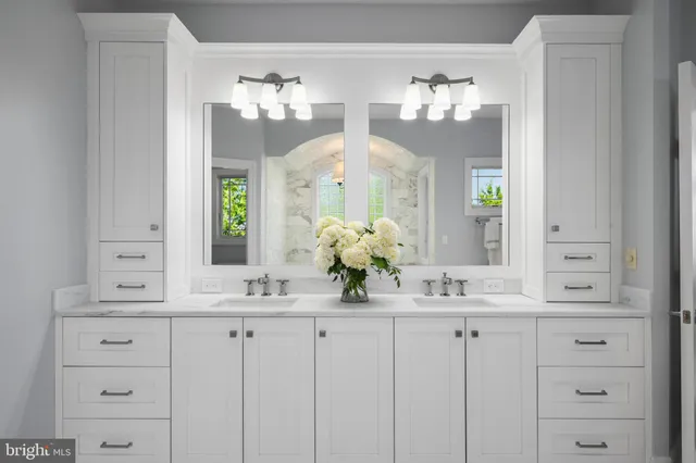 a bathroom with double vanity sinks and a mirror