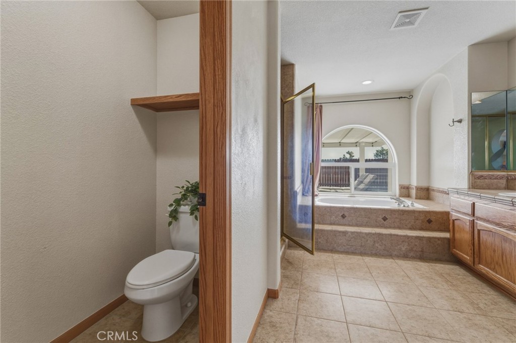 19501 Kinai Road Apple Valley, CA 92307 - Photo 29 of 49 a bathroom with a granite countertop toilet a sink and a bathtub