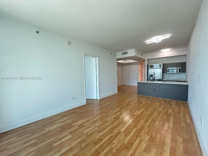 a view of a kitchen with kitchen island wooden floor and window