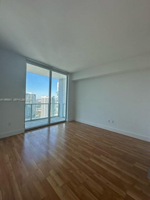 55 Southeast 6th Street, Unit 4100 Miami, FL 33131 - Photo 5 of 10 a view of an empty room with wooden floor and a window
