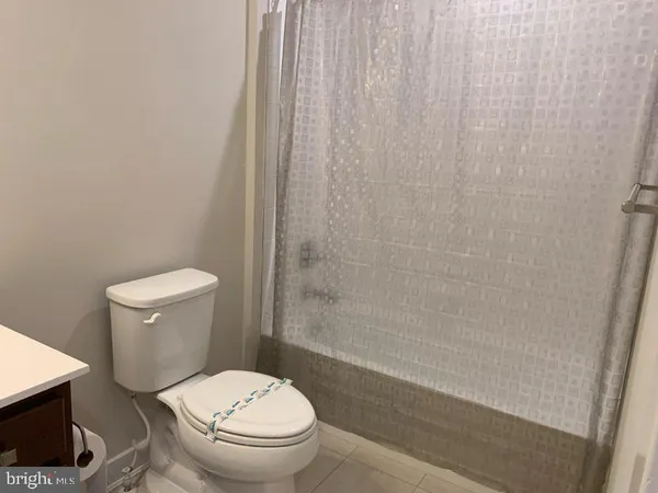 a white toilet sitting next to a shower curtain