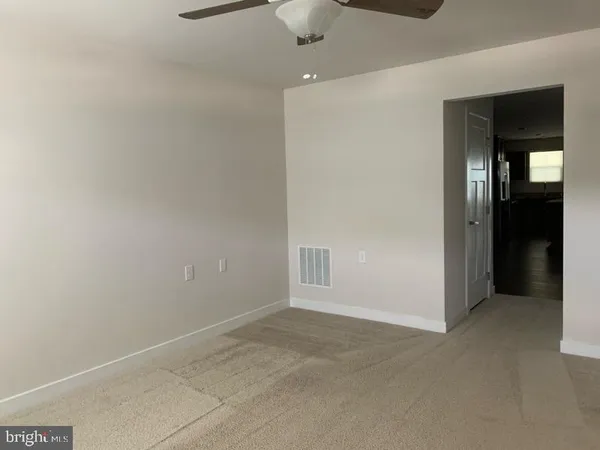 an empty room with closet and fan