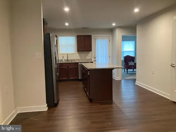 a kitchen with stainless steel appliances granite countertop a sink cabinets and wooden floor
