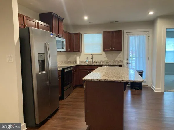 a kitchen with stainless steel appliances a refrigerator a sink a stove and cabinets