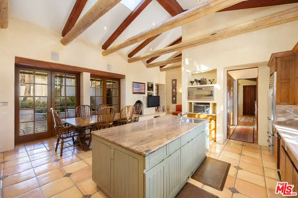a dining hall with couches a flat screen tv and couches with wooden floor