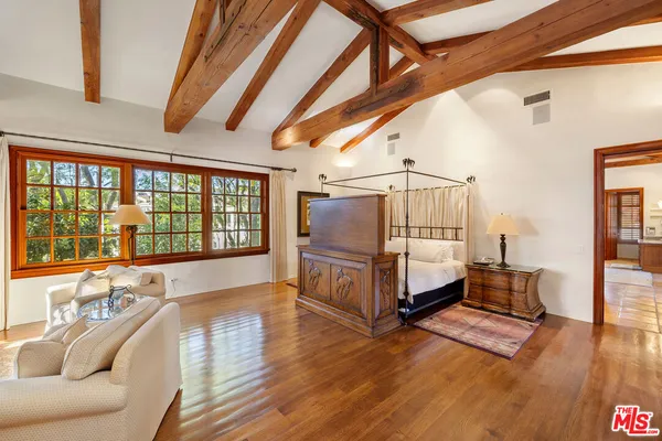 a view of a hallway with wooden floor and a living room