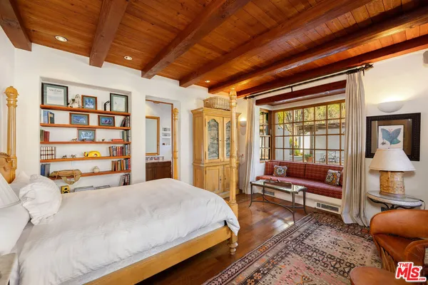 a large bedroom with a bed and wooden floor