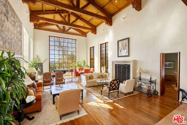 a living room with fireplace furniture and a large window