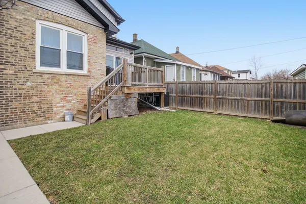a view of a house with a yard and sitting area