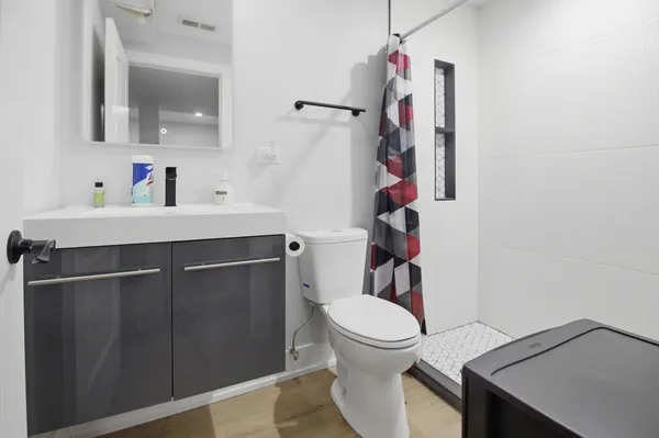a bathroom with a sink vanity mirror and toilet
