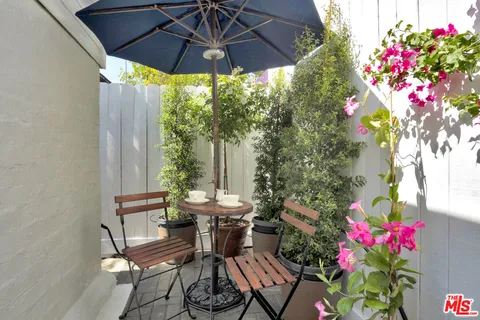 a view of a patio with table and chairs under an umbrella