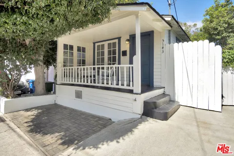 a view of a house with a wooden fence