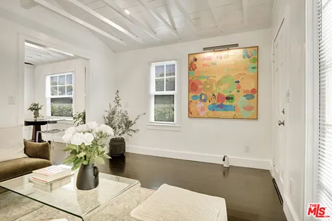 a white table with a vase and flowers on it