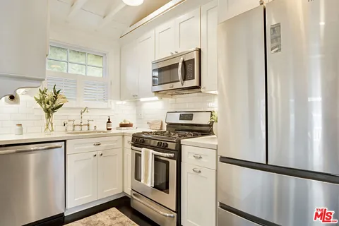 a kitchen with stainless steel appliances white cabinets and a granite counter tops
