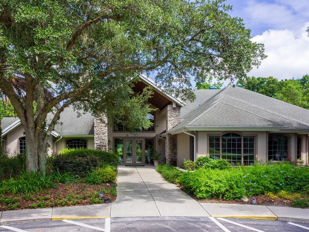 6635 Southwest 113th Place Ocala, FL 34476 - Photo 42 of 43 a front view of a house with a yard and potted plants