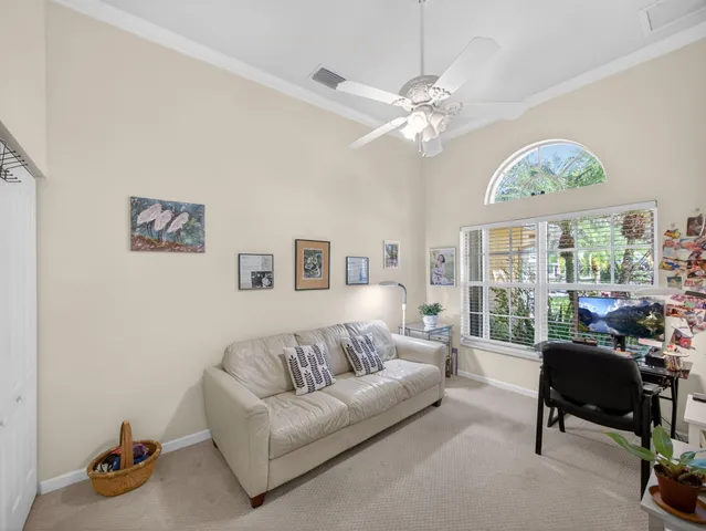 a living room with furniture a chandelier and a large window