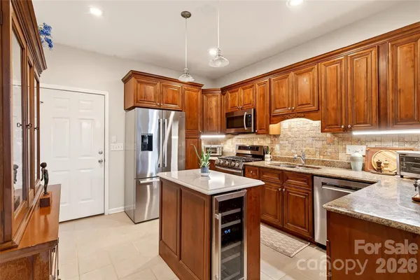 a kitchen with stainless steel appliances granite countertop a sink stove and refrigerator