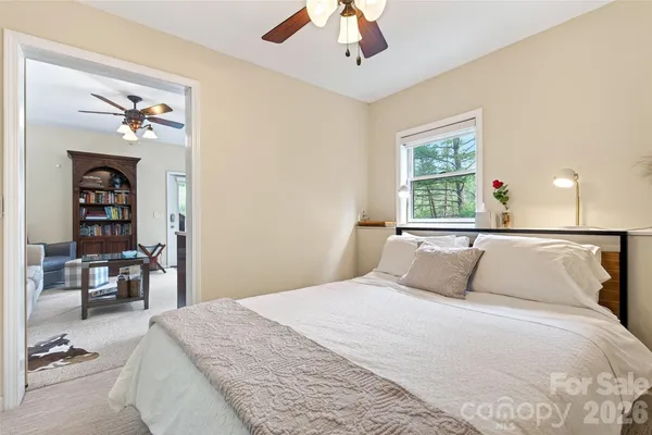 a bedroom with a large bed and a chandelier