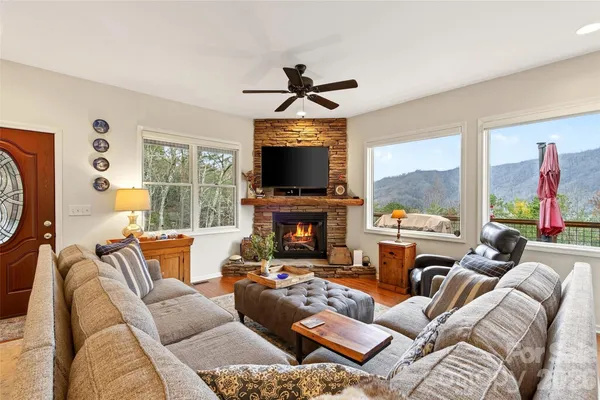 a living room with furniture a fireplace and a large window