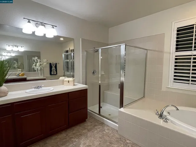 a bathroom with a double vanity sink mirror and shower