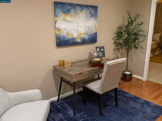 a view of a workspace with furniture and wooden floor