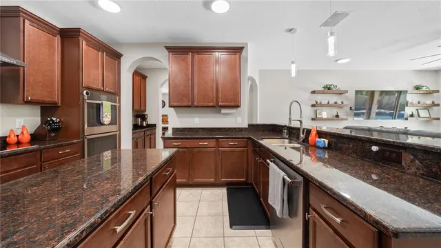 a kitchen with stainless steel appliances granite countertop a refrigerator and a stove top oven
