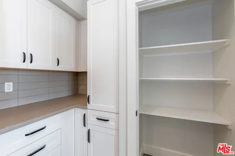 a view of white cabinets and a wooden floor