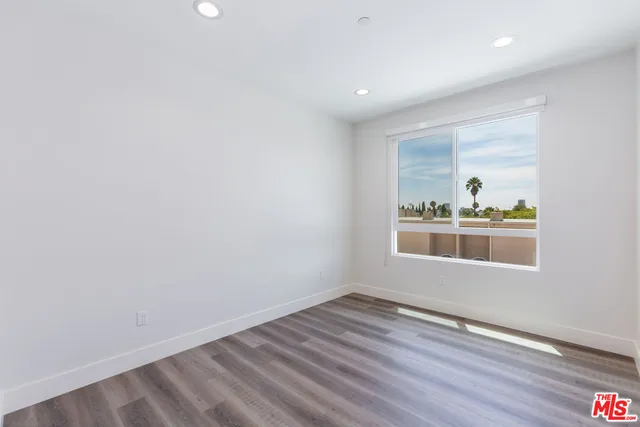 an empty room with wooden floor and a window