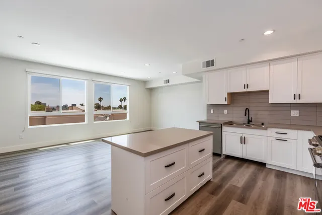 a kitchen with white cabinets and white appliances
