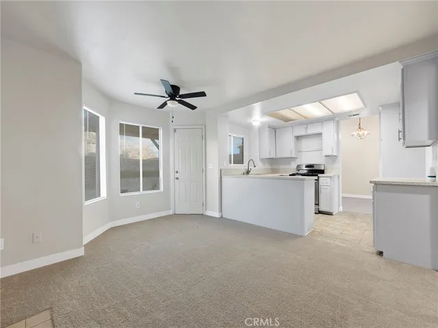 a view of a kitchen with furniture and a ceiling fan