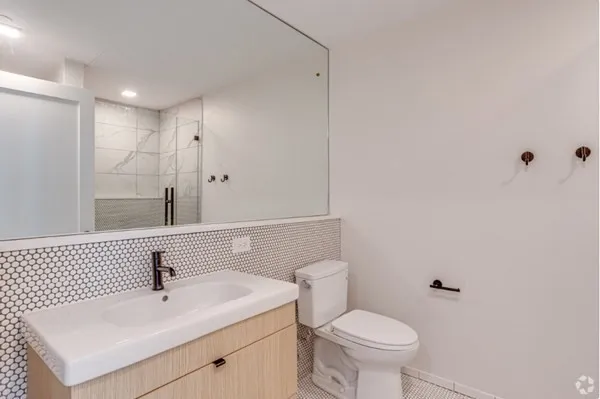 a bathroom with a sink a toilet and shower