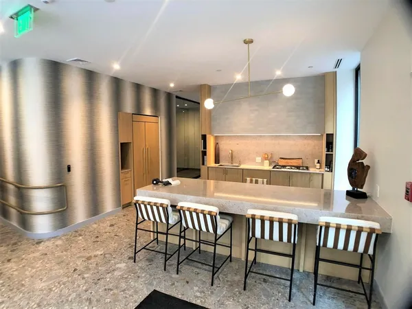 a kitchen with stainless steel appliances kitchen island granite countertop a refrigerator a stove a kitchen island with a dining table and chairs