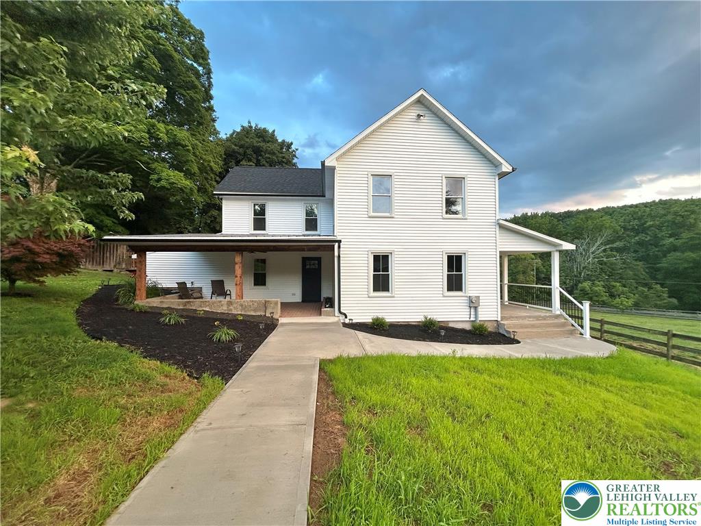 72 Allegheny Road Mount Bethel, PA 18343 - Photo 45 of 72 White siding and a welcoming porch create charming curb appeal against a lush, hilly backdrop.
