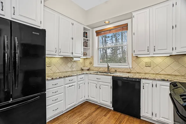 a kitchen with granite countertop a sink stainless steel appliances and cabinets