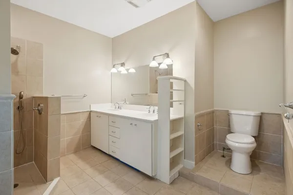 a spacious bathroom with a double vanity sink toilet and shower