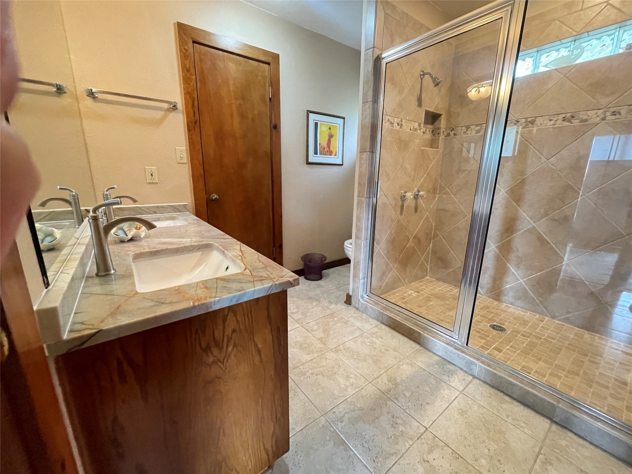 919 Little Ranches Road Wimberley, TX 78676 - Photo 12 of 13 Dual vanities with polished countertops and a spacious walk-in shower elevate this bathroom's appeal.