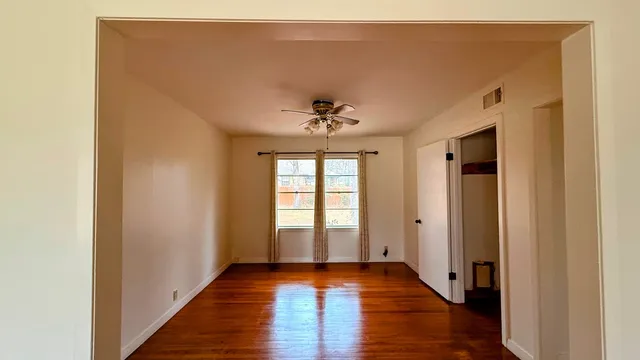 a view of a hallway with wooden floor and a chandelier