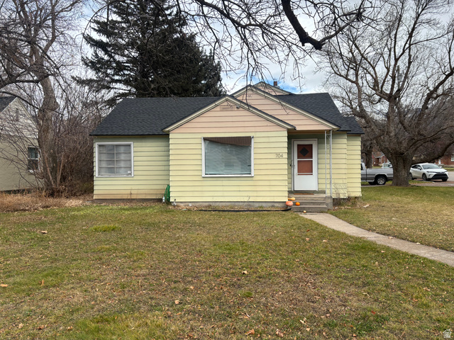 704 North 200 East Logan, UT 84321 - Photo 2 of 24 Bungalow-style home featuring a shingled roof, a front yard, and entry steps