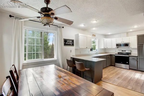 a large kitchen with kitchen island a large counter top space appliances and cabinets