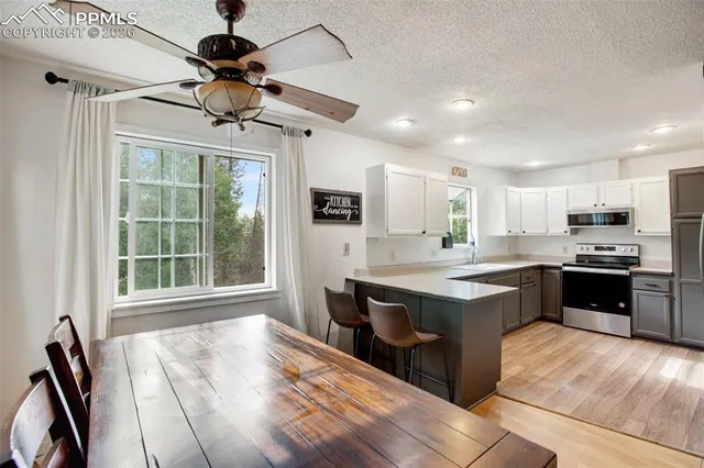 a large kitchen with kitchen island a large counter top space appliances and cabinets