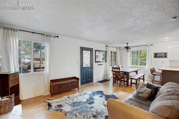 a living room with furniture wooden floor and windows