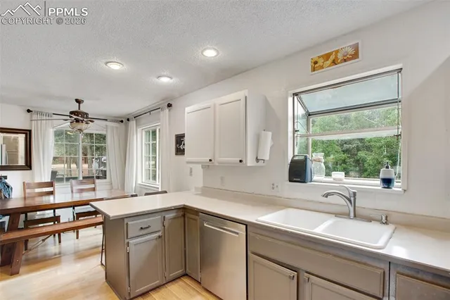 a kitchen with a sink window and cabinets