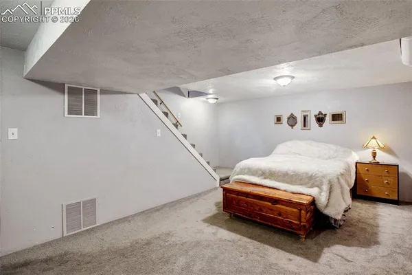 a spacious bedroom with a bed and a night stand