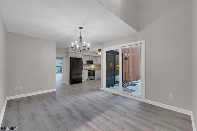 a view of a room with wooden floor chandelier and windows