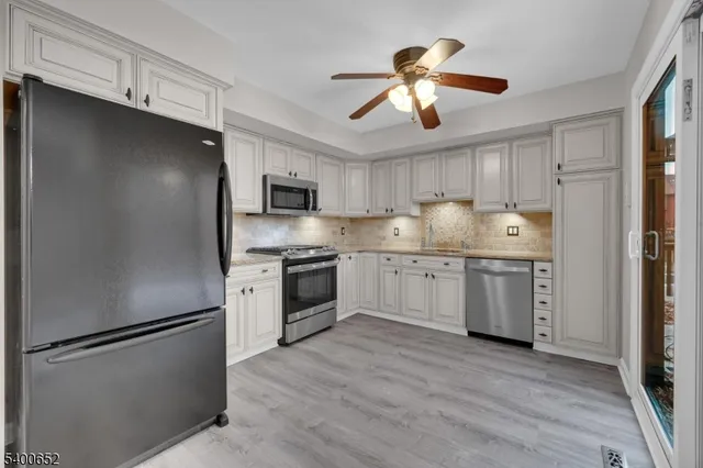 a kitchen with a refrigerator sink and cabinets