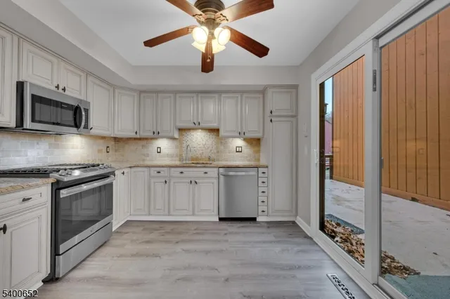 a kitchen with granite countertop a stove top oven a sink and dishwasher