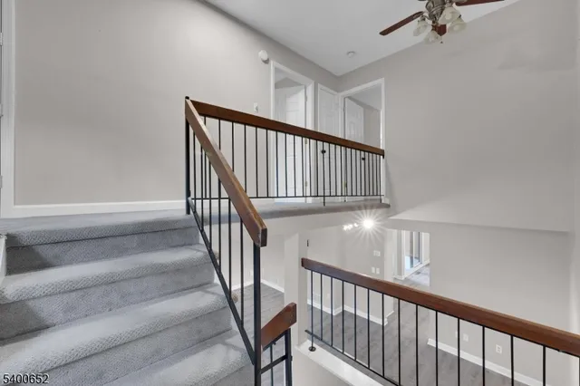 a view of staircase with railing and white walls