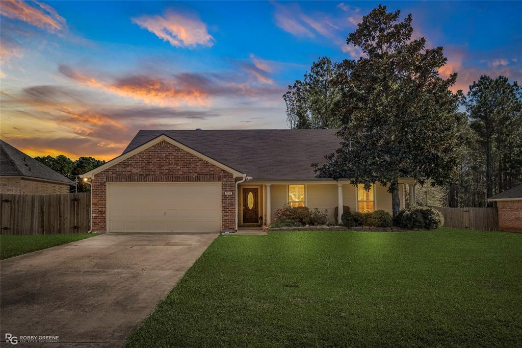 Ranch-style house featuring a garage, driveway, brick siding, a shingled roof, and covered porch