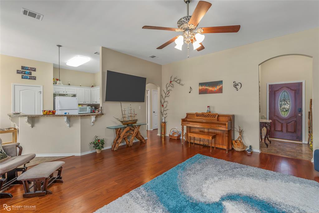 7193 Laurel Ridge Drive Greenwood, LA 71033 - Photo 23 of 40 Living room featuring arched walkways, dark wood-style flooring, and a ceiling fan
