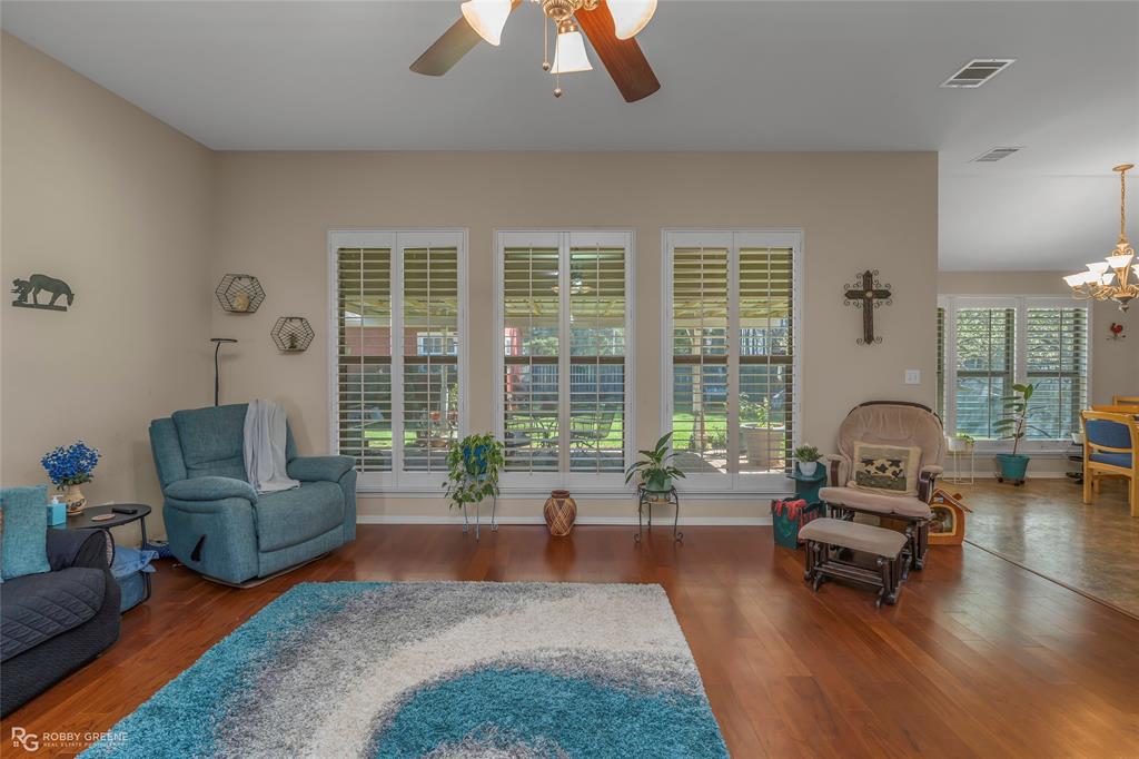 7193 Laurel Ridge Drive Greenwood, LA 71033 - Photo 25 of 40 Living area featuring dark wood finished floors, ceiling fan, and a chandelier